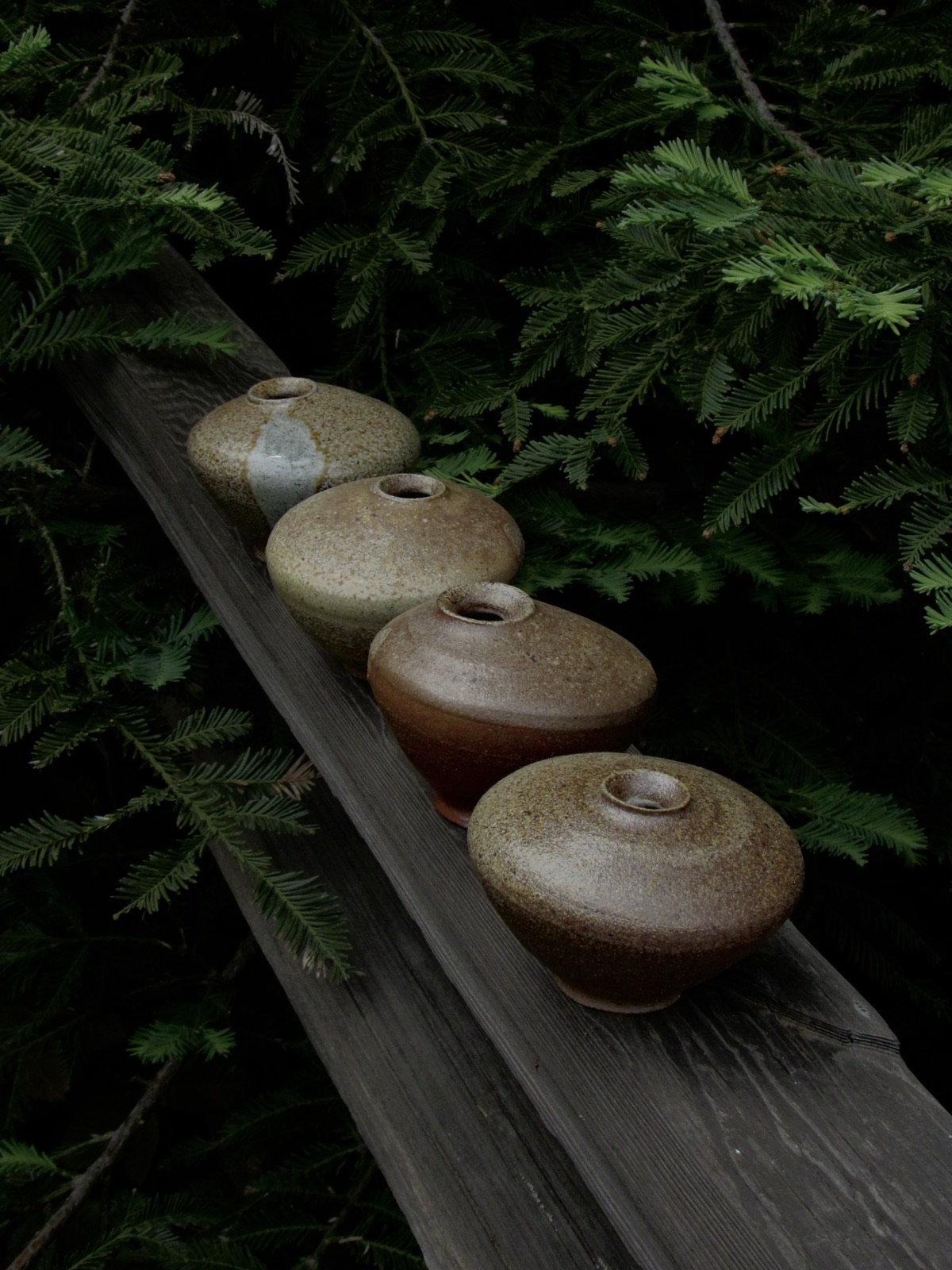 Wood-fired ceramic bud vases arranged outdoors