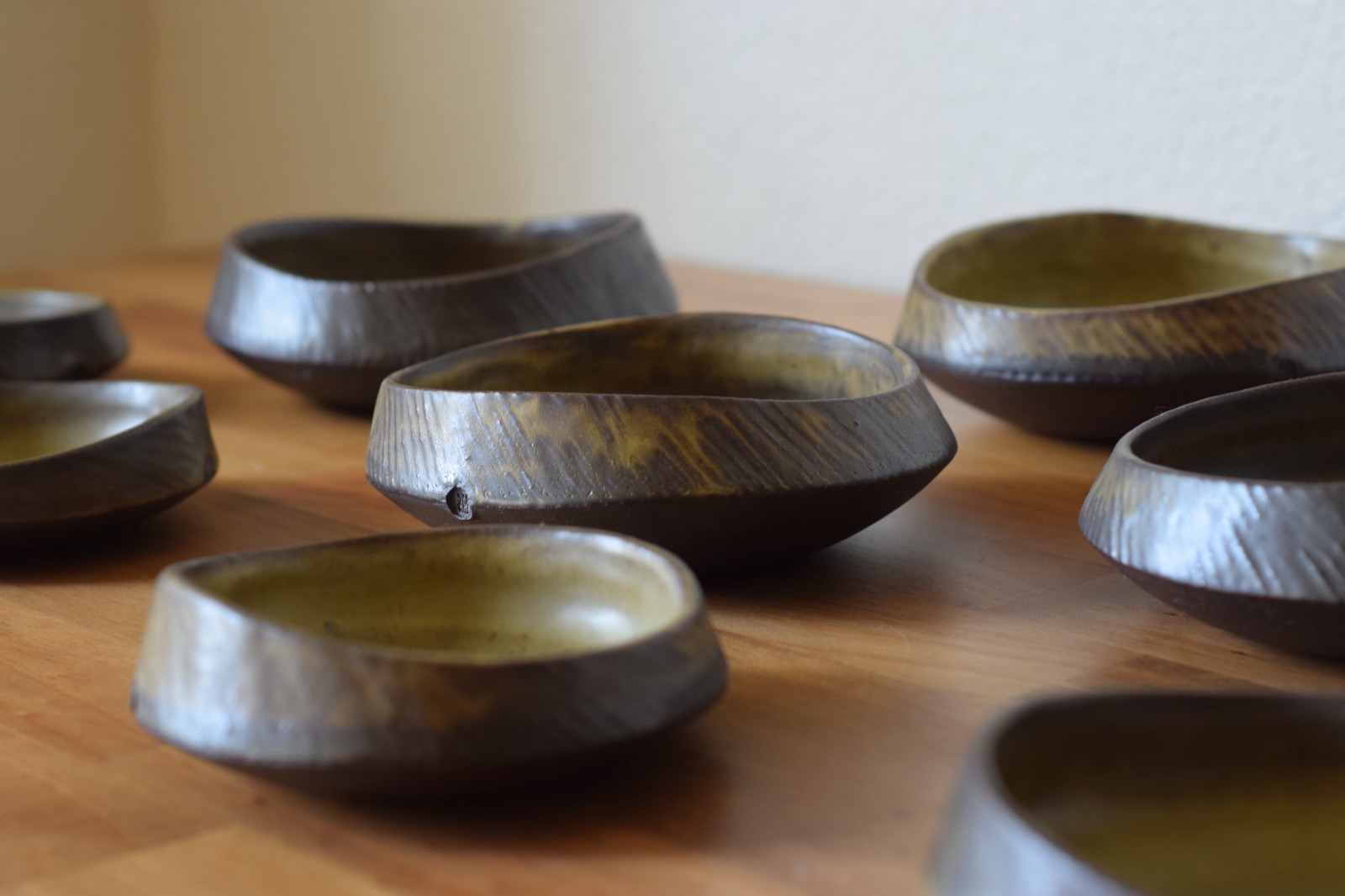Carved dark stoneware bowls with chartreuse glazed interiors