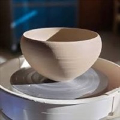 Freshly thrown ceramic bowl turning on a pottery wheel